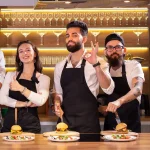 happy-chef-and-his-colleague-standing-at-kitchen-a-2025-02-24-19-23-55-utc 1